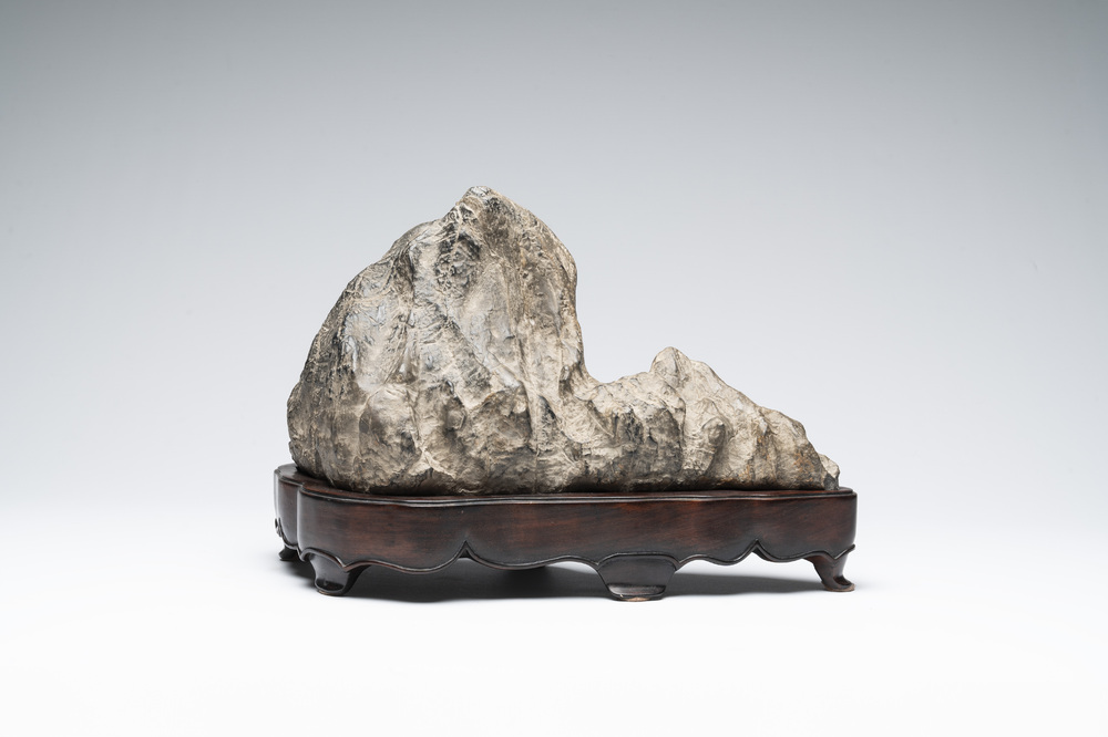 A Chinese Lingbi stone scholar's rock on wooden stand, 20th C.