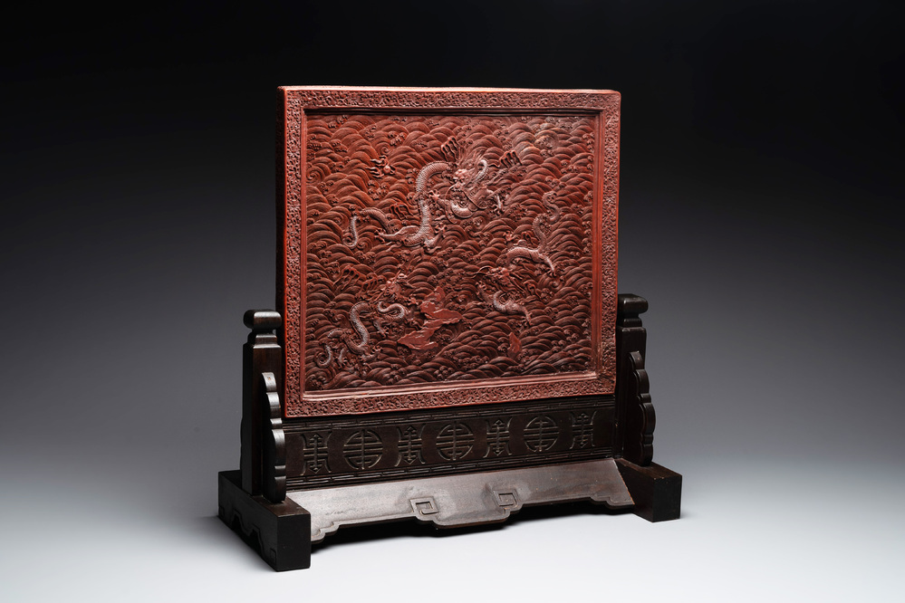 A rectangular Chinese carved red lacquer 'dragon' table screen, later wooden stand, Qianlong