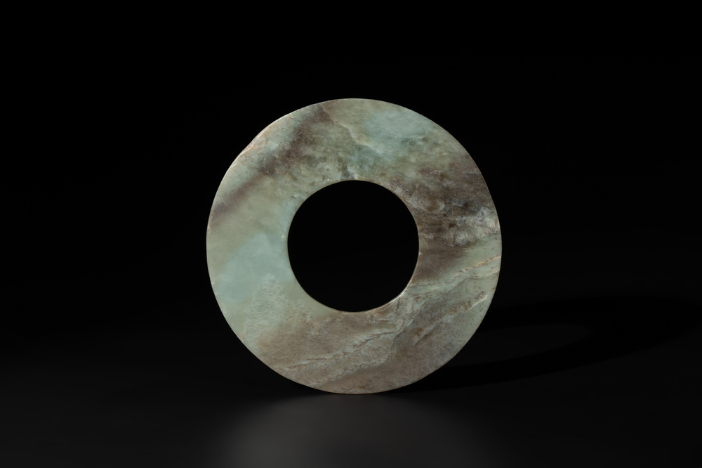 A Chinese celadon and russet jade 'bi' disc, Neolithic period