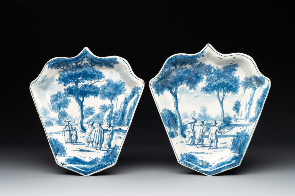 A pair of fine blue and white Dutch Delft leaf-shaped dishes with travellers in a landscape, early 18th C.