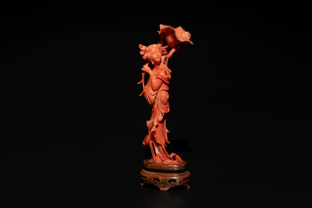 A Chinese red coral figure of a standing lady holding a flower, 19/20th C.
