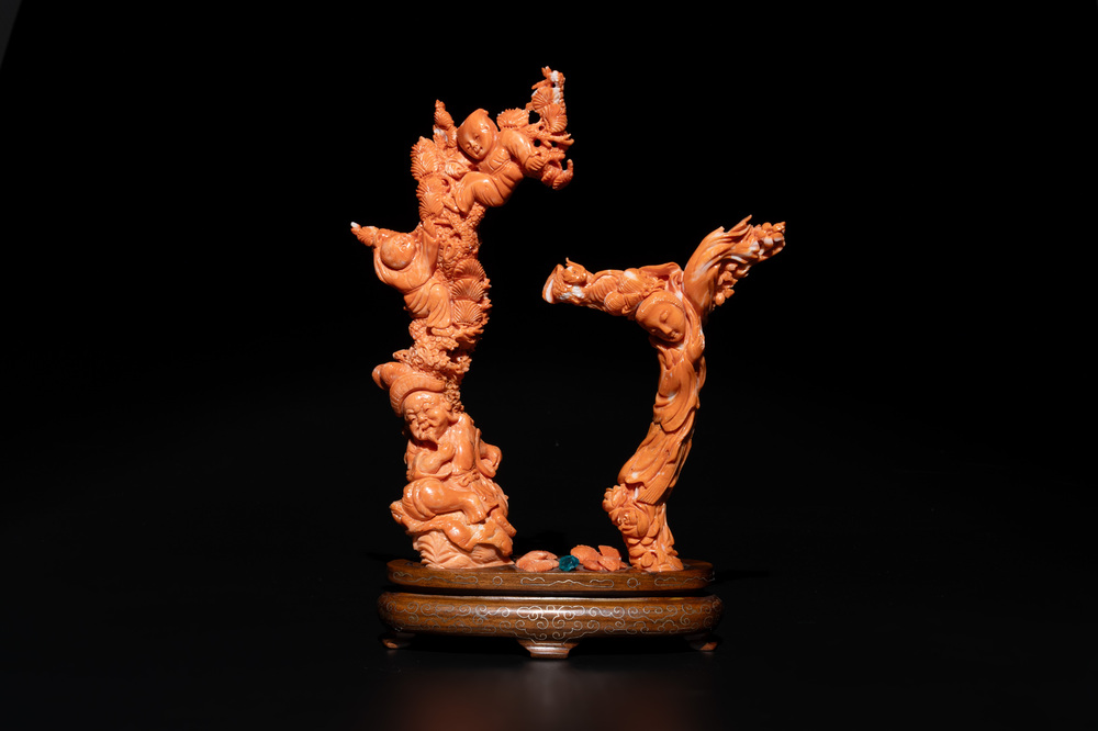 A Chinese pink-orange coral group of a goddess of spring, a wise man and children in a pine tree, 19/20th C.