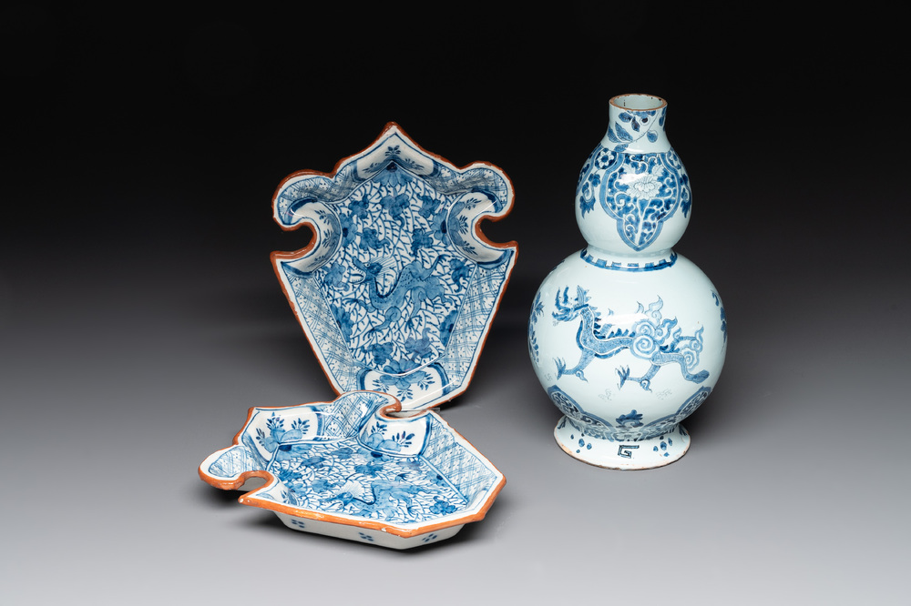 A pair of blue and white Dutch Delft fleur-de-lys-shaped 'Chinese dragon' dishes and a double gourd vase, 17/18th C.