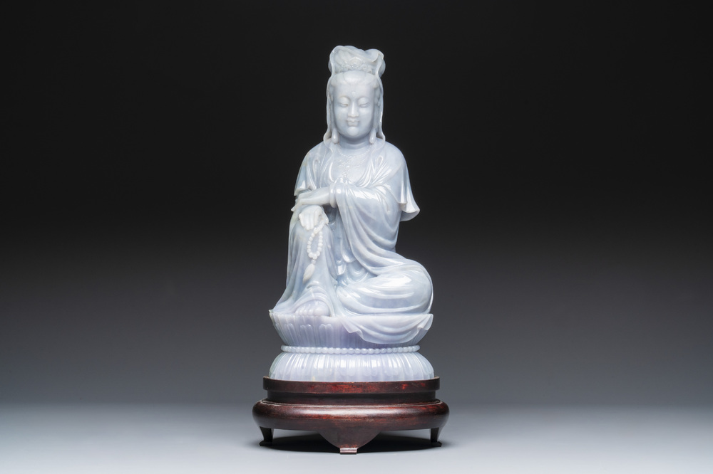 An exceptional and large Chinese carved pale lavender jadeite Guanyin on a wooden stand, Republic