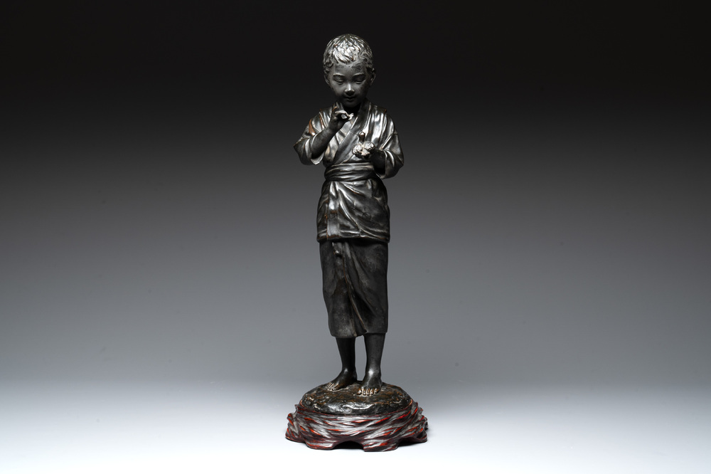 A Japanese bronze sculpture of a boy feeding a bird on a wooden stand, signed, Meiji, 19th C.