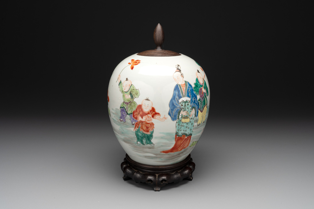 A Chinese famille rose 'ladies and boys' jar with wooden cover and stand, Yongzheng/Qianlong