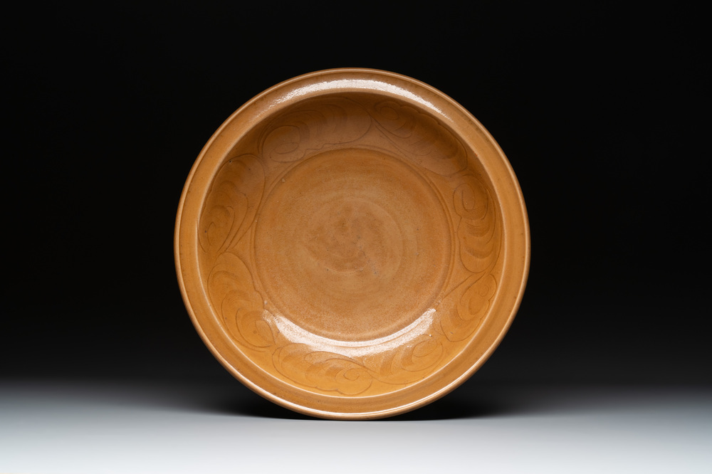 A Chinese incised brown-glazed Longquan dish with floral design, Ming