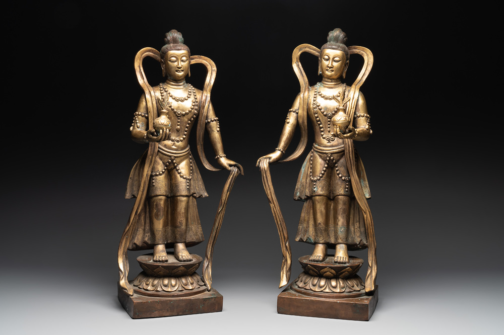 A pair of large Chinese gilt bronze offering figures on stand, 19th C.