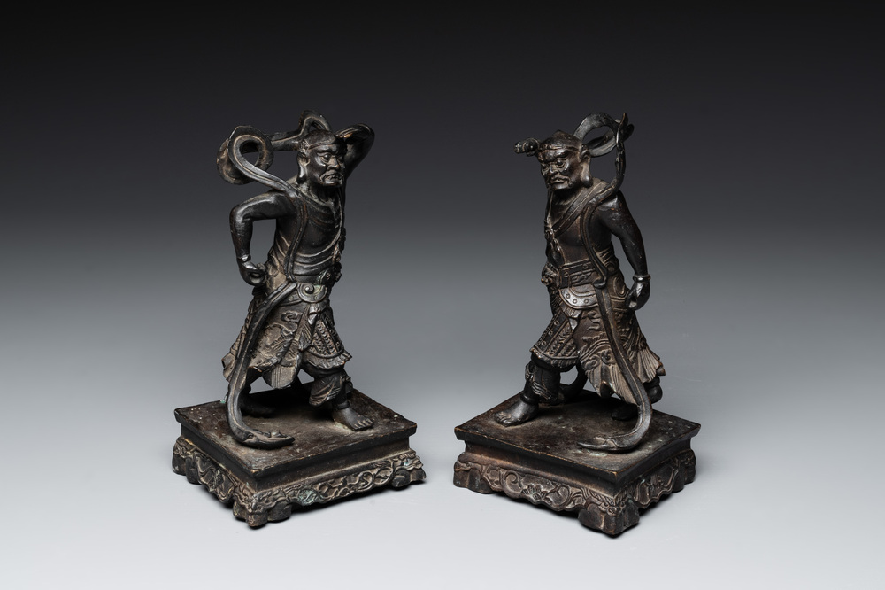 A pair of Chinese bronze guardians on stands, 17/18th C.