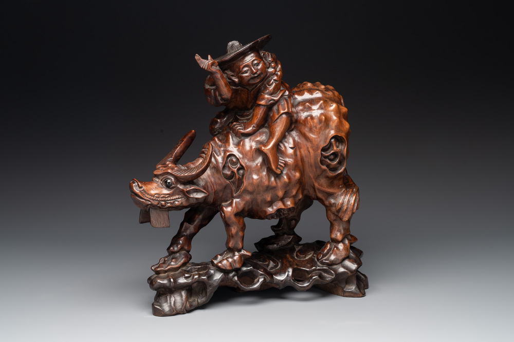 A Chinese carved wooden group of a boy riding a water buffalo, 20th C.