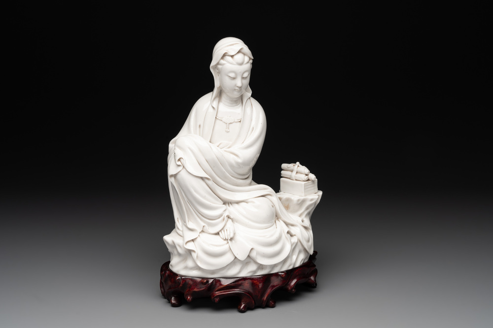 A Chinese Dehua blanc de Chine figure of a seated Guanyin on wooden stand, 19/20th C.