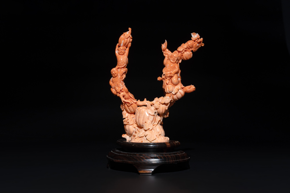A Chinese red coral group of boys and bitter gourds on wooden stand, 19/20th C.