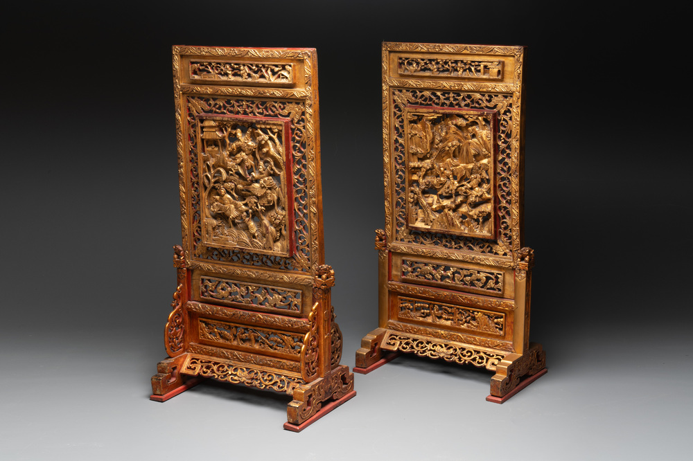 A pair of Chinese gilt-lacquered openworked wooden table screens with warriors on horseback, 19th C.