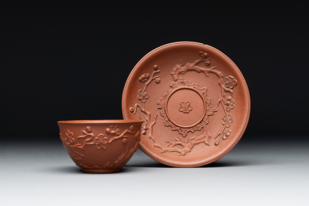 A Chinese Yixing stoneware cup and saucer with plum blossom relief design, Kangxi