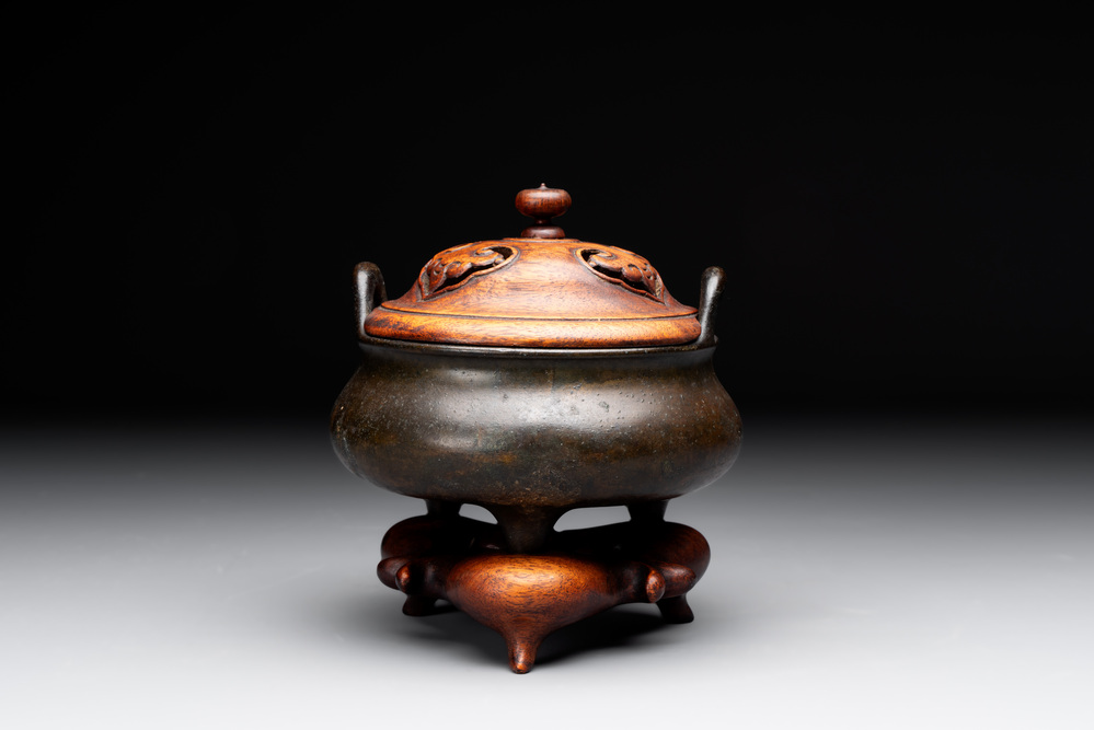A Chinese bronze tripod censer with wooden cover and stand, Xuande mark, 18/19th C.