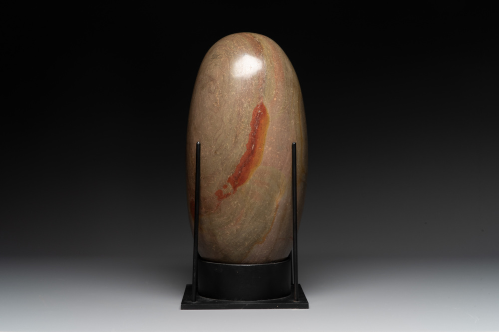 A large Shiva lingam stone on a metal stand