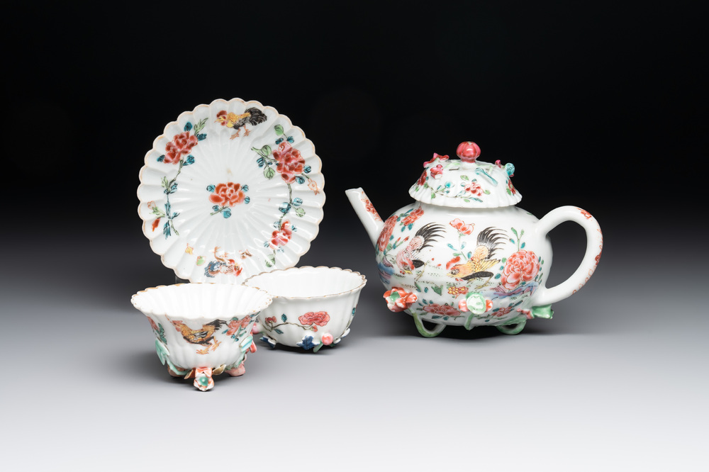 A Chinese famille rose 'rooster' teapot with applied floral design, two cups and a saucer, Yongzheng/Qianlong