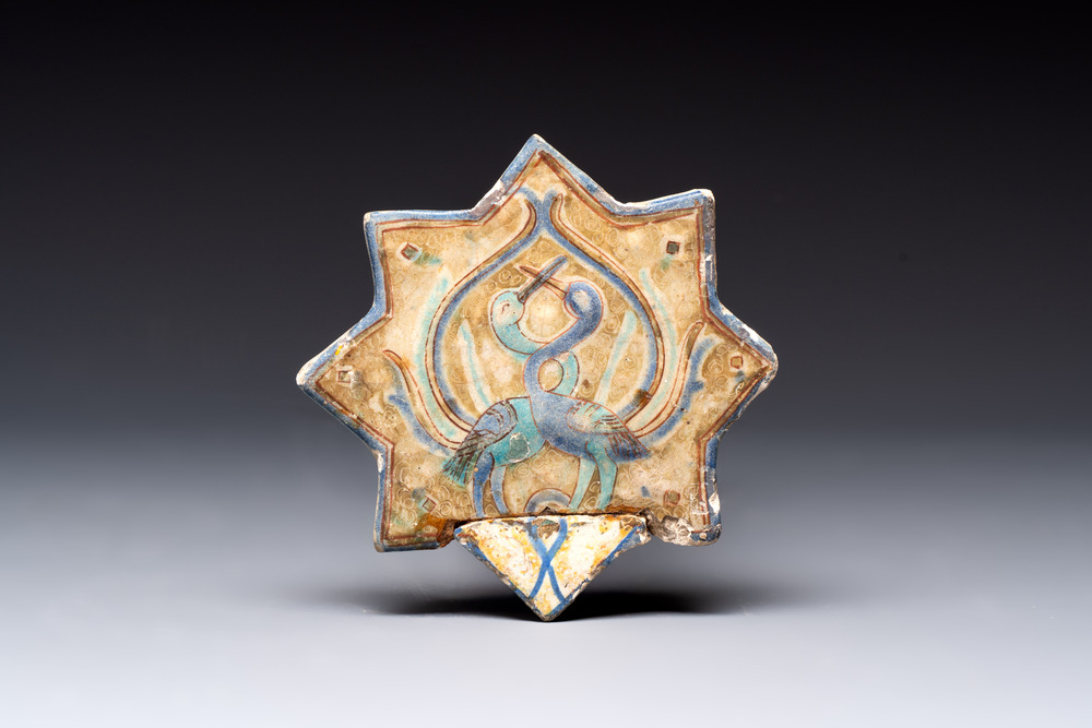 A polychrome Kashan relief-moulded star-shaped tile with herons, Persia, 14th C.
