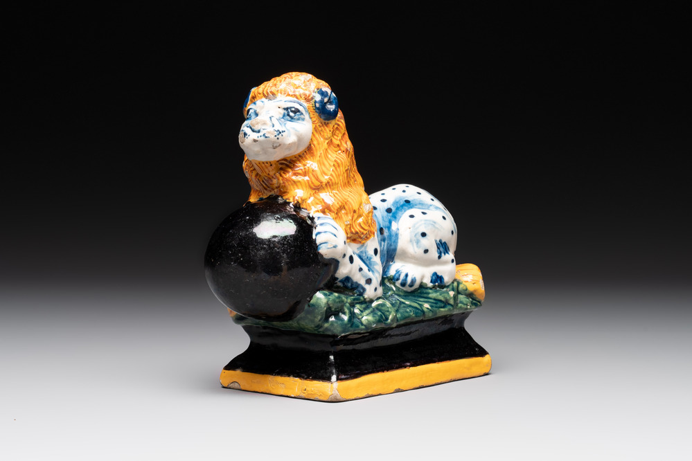 A rare black-ground polychrome Dutch Delft model of a lion with a ball, 18th C.