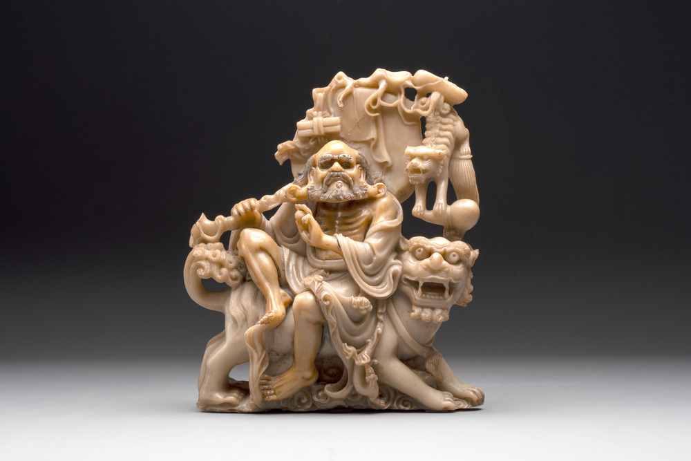 A Chinese carved group of a Luohan with two tigers, 20th C.