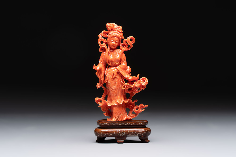 A Chinese red coral figure of a goddess on wooden stand, 19/20th C.