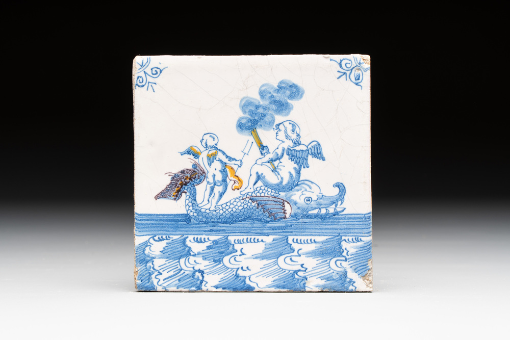 A fine partly polychrome, blue and white Dutch Delft 'sea creature with putti' tile, early 18th C.