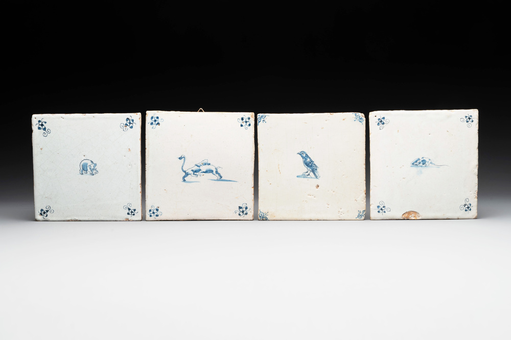 Four blue and white Dutch Delft tiles with an elephant, bird, mouse and boars, 17th C.