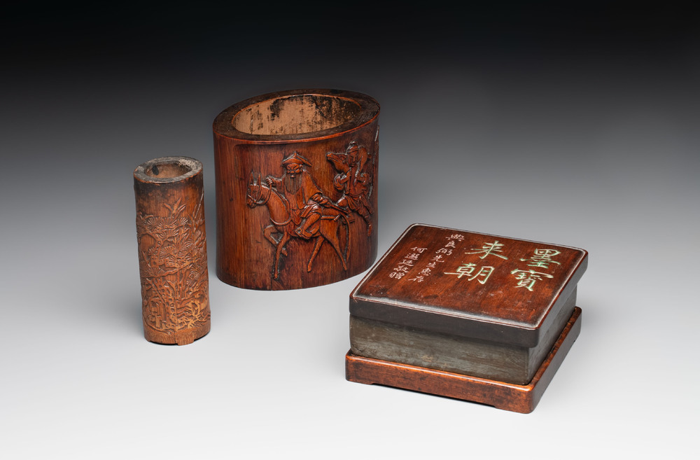 Two Chinese carved bamboo brush pots and an ink stone with wooden cover and stand, signed He Xuanting 何選廷 and Dian Liangbi 典良弼, 19th C.