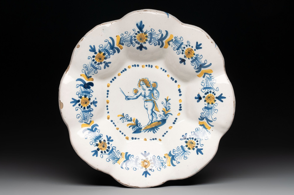 A blue, white and yellow Dutch Delftware dish with a putto, Delft or Haarlem, 17th C.
