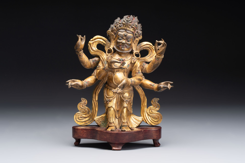 A Sino-Tibetan gilt-bronze figure of White Mahakala on wooden stand, 18th C.