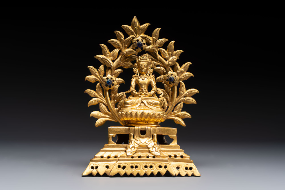 A Nepalese gilt-bronze Buddha on an inscribed throne with a mandorla, 19th C.