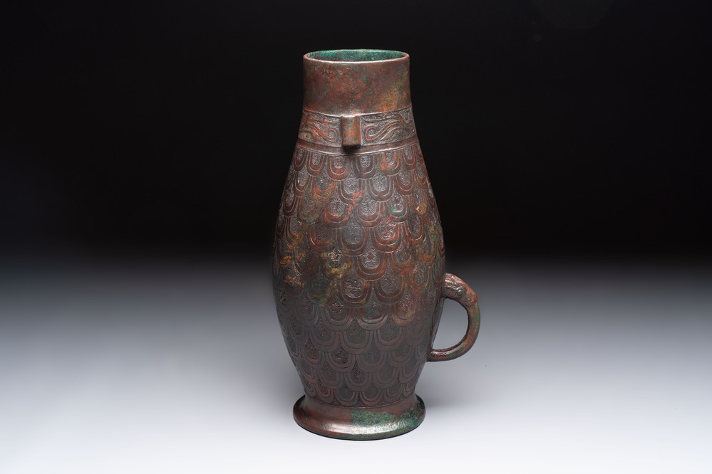A Chinese archaic bronze inscribed wine vessel with scale design, 'hu 壺', Zhou