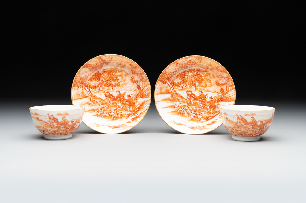 A pair of Chinese iron-red-decorated 'deer hunting' cups and saucers, Qianlong