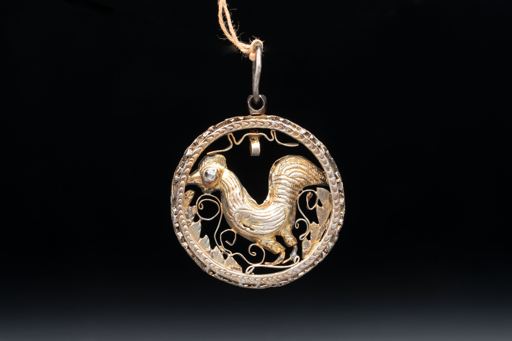 A gilt-brass 'Rooster' amulet with glass-inlaid eyes, 17th C. or later