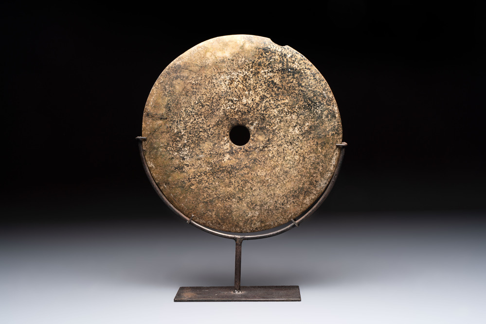 A Chinese archaic calcified jade 'bi' disc on an iron stand, Zhou