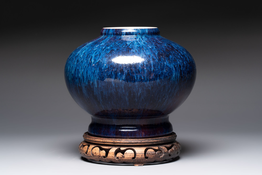 A Chinese flamb&eacute;-glazed vase on a wooden stand, 19th C.