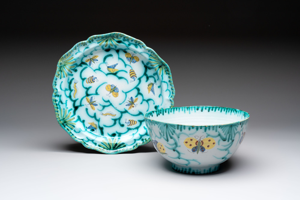 A large polychrome Brussels faience bowl and stand with butterfly and peacock design, 18th C.
