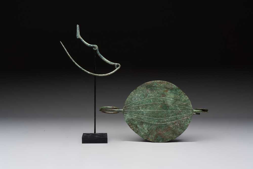 A large bronze Etruscan bow-shaped fibula and a Hungarian fibula with spring clasp, 12/7th C. B.C.