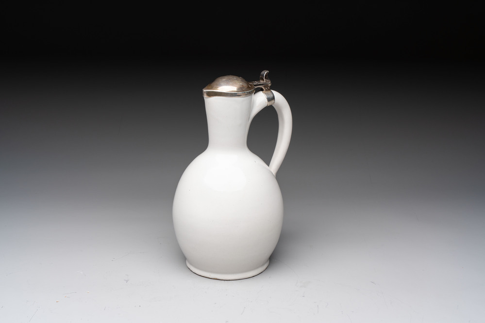 A fine white-glazed Delftware jug with silver cover, 17th C.
