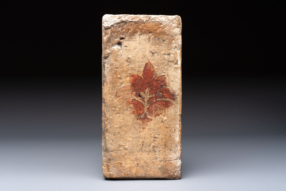 A Spanish cold-painted 'socarrat' or ceiling tile with stylised floral design, 15th C.