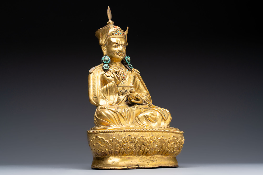 A Tibetan gilt-bronze figure of Padmasambhava holding a cup and a vajra, 17th C. or later