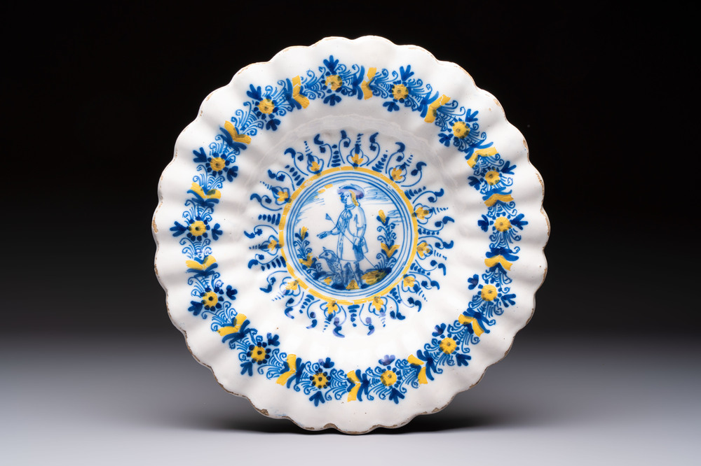 A polychrome lobed Dutch Delft 'Compendario' dish with a shepherd with his dog, 17th C.