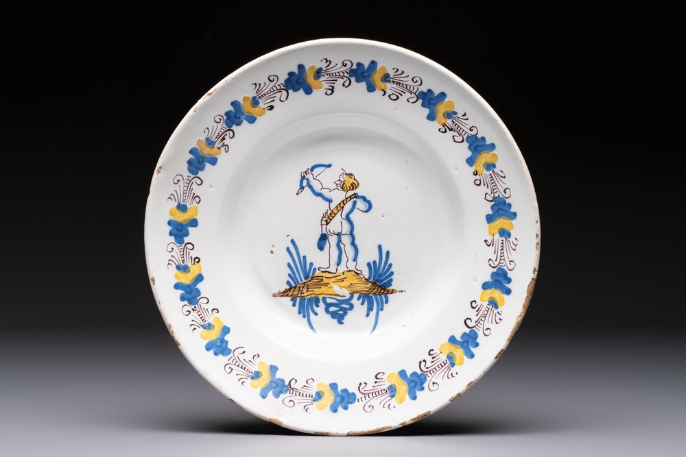 A rare polychrome Dutch Delftware 'Compendario' dish with an arching putto, probably Verstraeten workshop, Haarlem, 17th C.