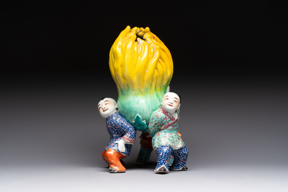 A Chinese famille rose figure of three boys holding a Buddha&rsquo;s hand, Republic