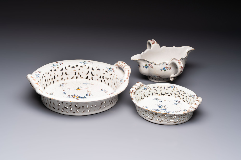Two reticulated Brussels faience 'A la Haie Fleurie' baskets and a sauce boat, 18th C.