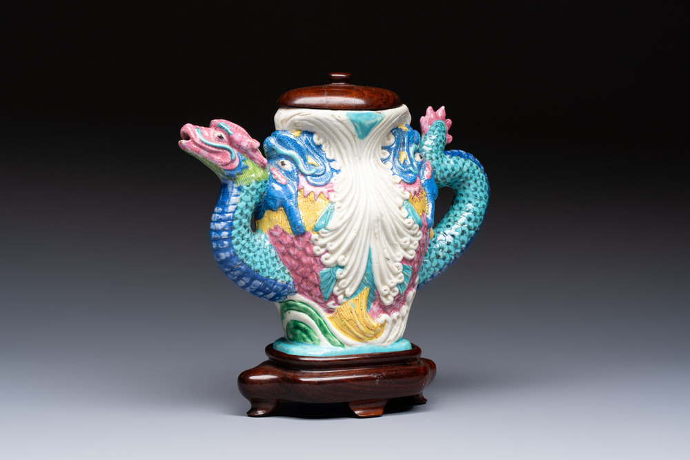 A Chinese famille rose ewer in the form of a dragon and two carps with wooden cover and stand, 19th C.