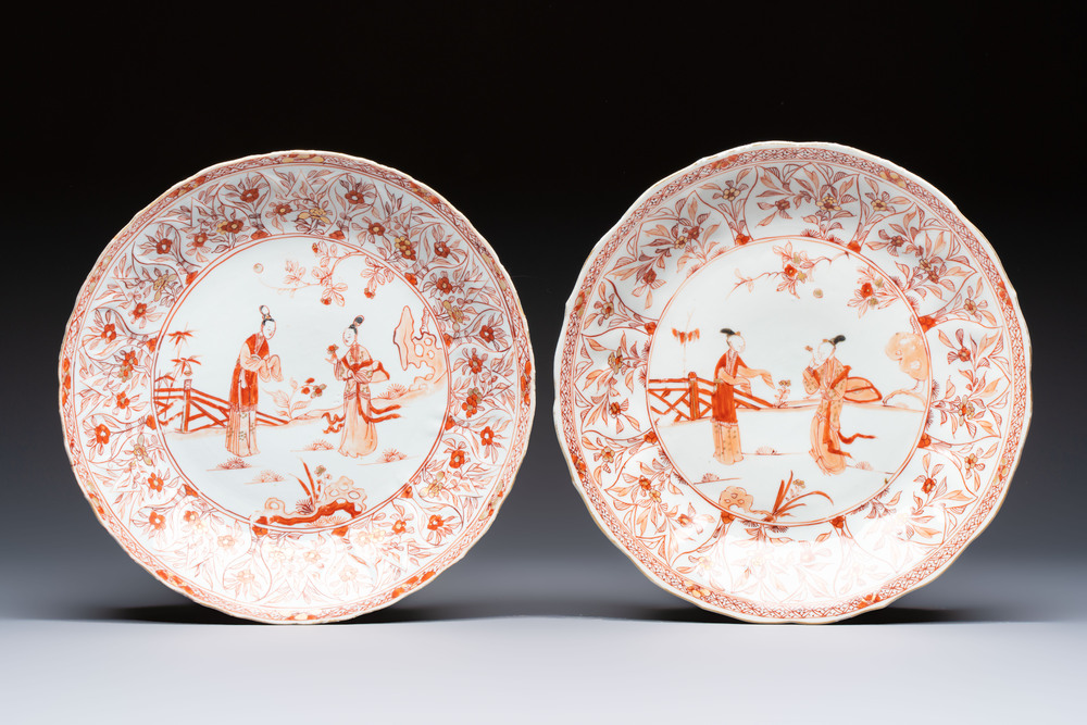 A pair of Chinese iron-red and gilt-decorated 'Elegant Beauties in a Garden' dishes, Kangxi