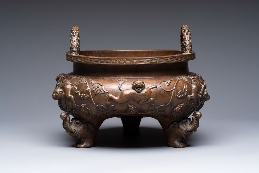 A rare Chinese bronze tripod censer with relief mythical animal and grape design, Xuande mark, 19th C.