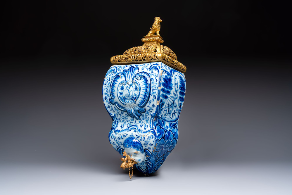 A large blue and white Dutch Delft 'Fountain of Youth' wall cistern with impressive reticulated gilt bronze cover, 18th C.