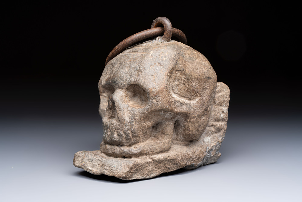 An Italian carved Serena stone 'Memento Mori' in the form of a skull with a wrought-iron suspension ring, probably Tuscany, 17th C.
